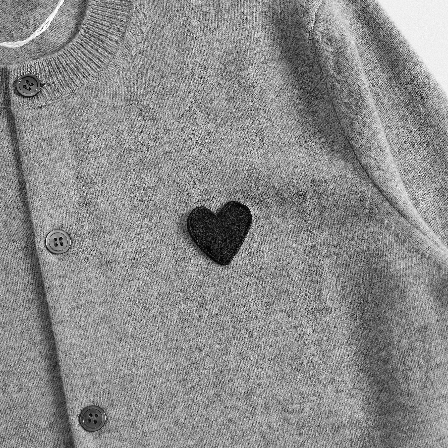 Dettaglio cuore cardigan classico lana 100% grigio con collo rotondo e dettaglio cuore nero  