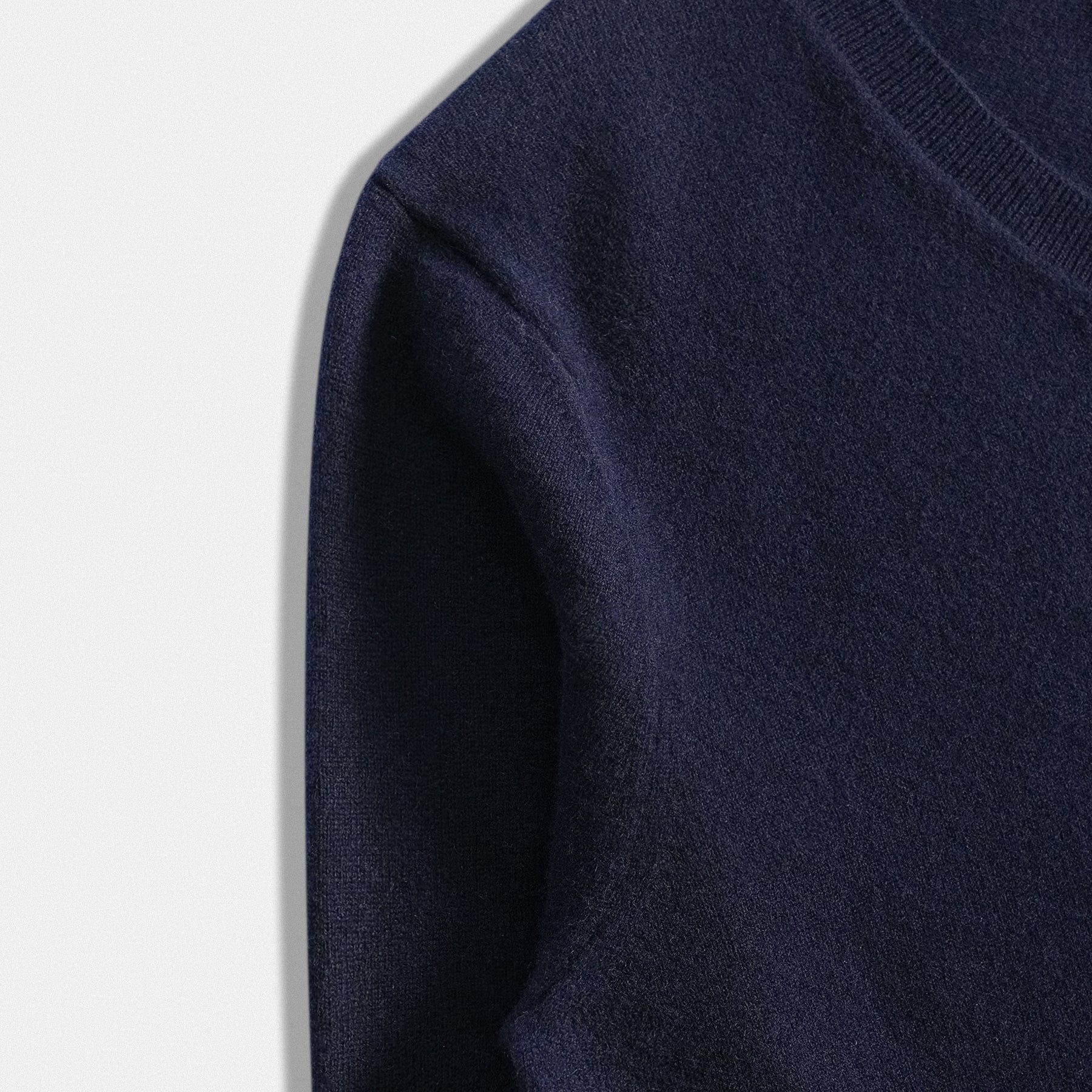 Dettaglio manica scollo a V del pullover in lana 100% con applicazione cuore in tessuto rosso vino