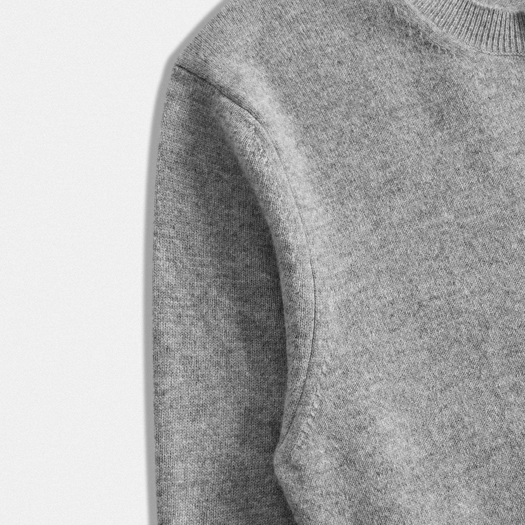 Dettaglio manica cardigan classico lana 100% grigio con collo rotondo e dettaglio cuore nero  