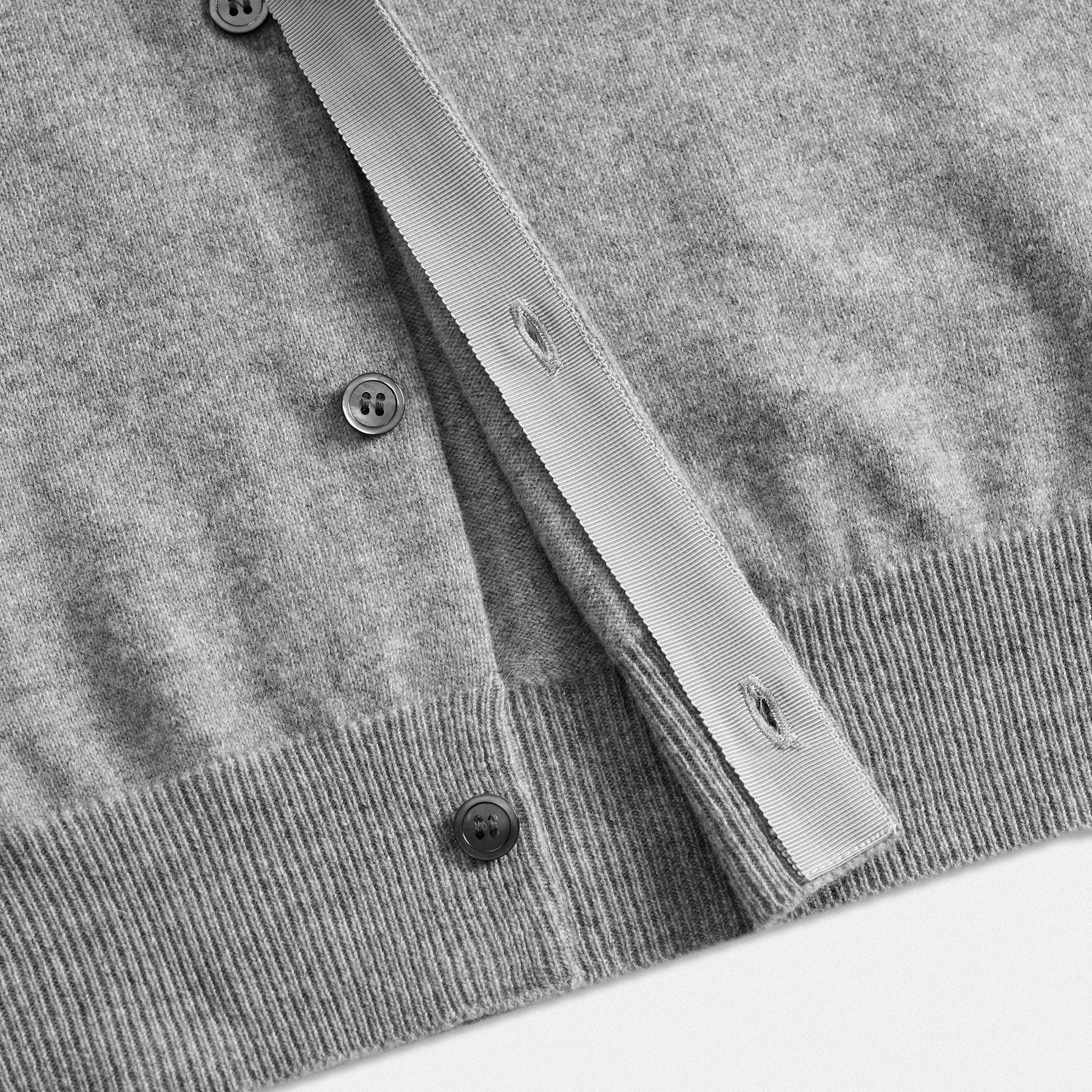 Dettaglio chiusura interna bottoni cardigan classico lana 100% grigio con collo rotondo e dettaglio cuore nero  