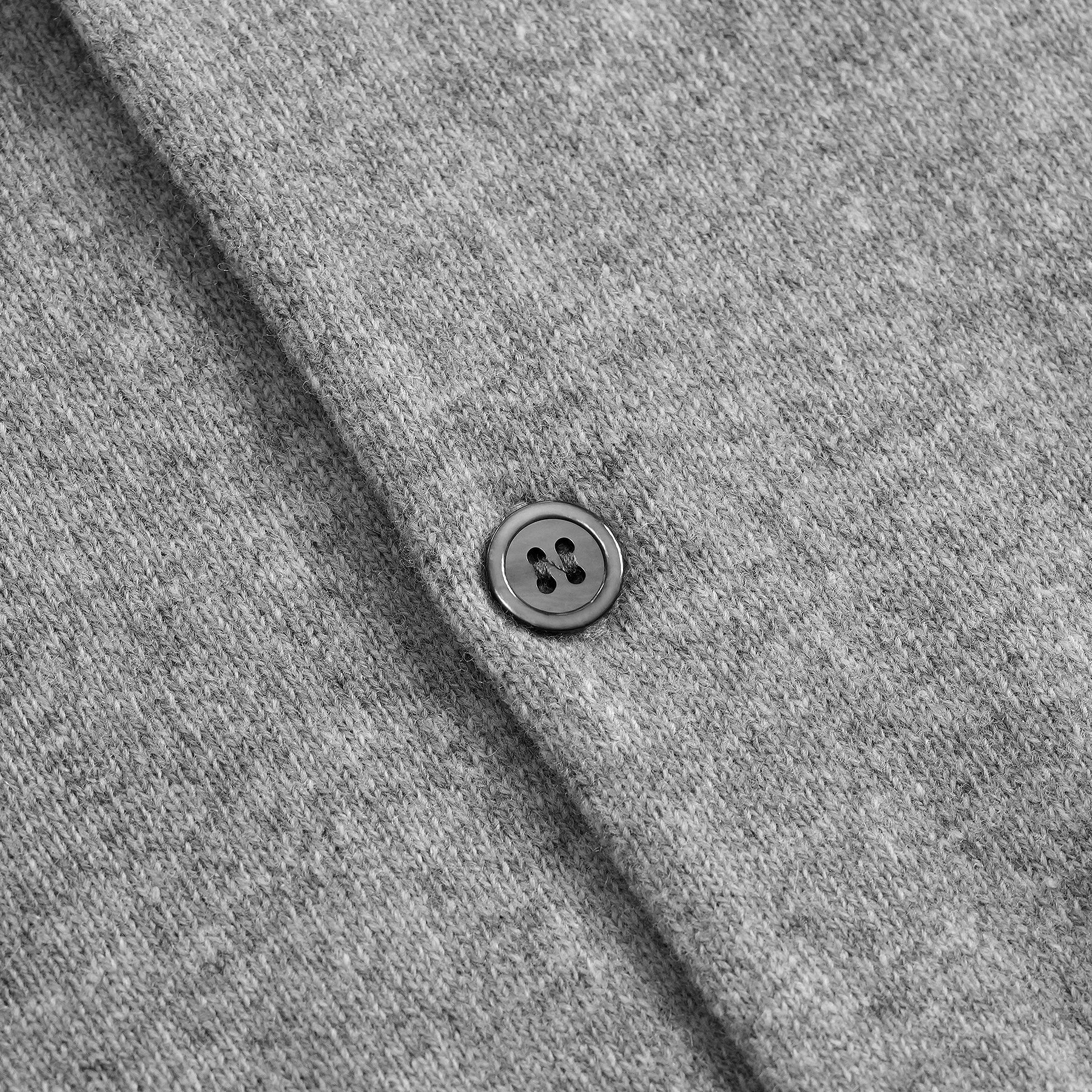 Dettaglio bottone cardigan classico lana 100% grigio con collo rotondo e dettaglio cuore nero  