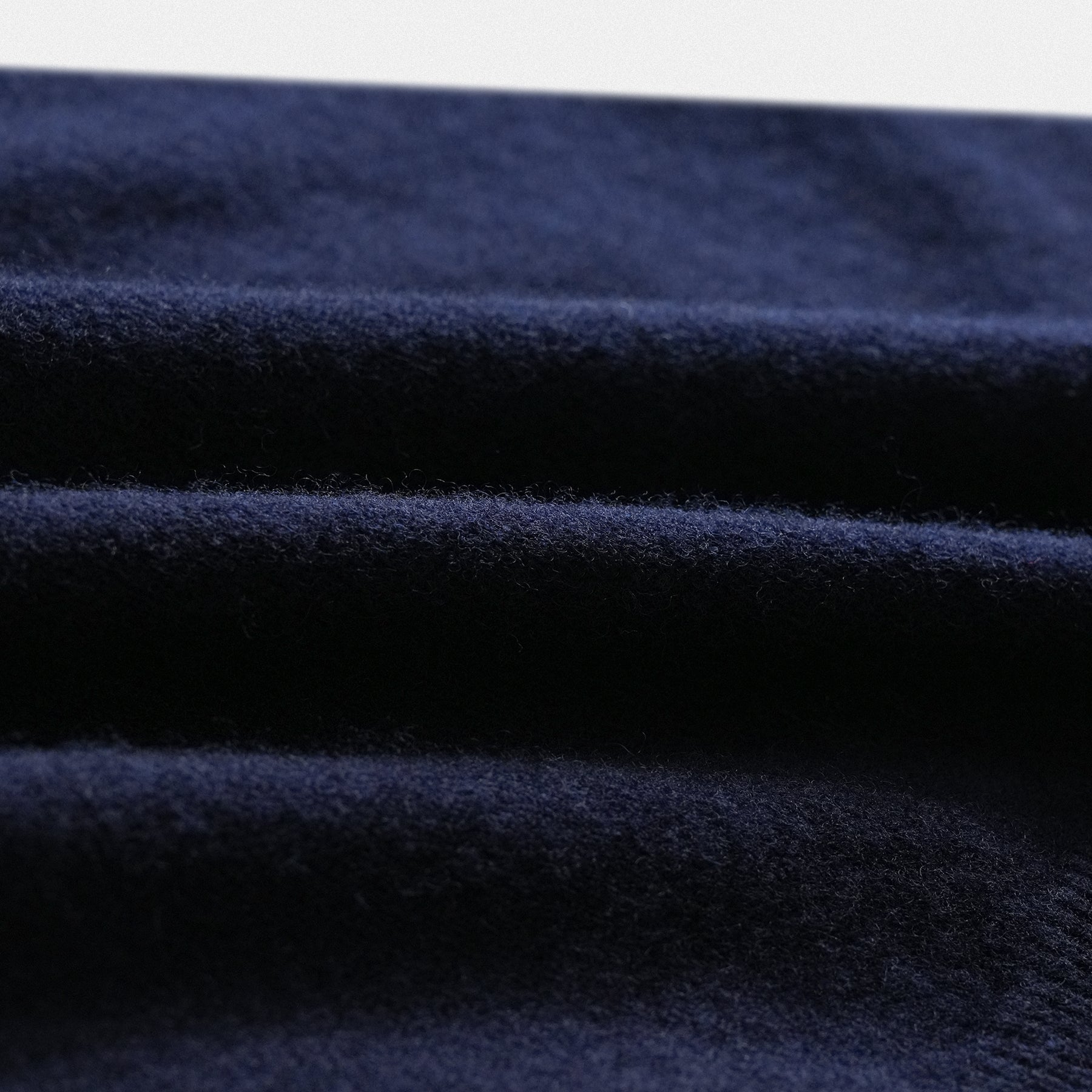 Dettaglio tessuto scollo a V del pullover in lana 100% con applicazione cuore in tessuto rosso vino